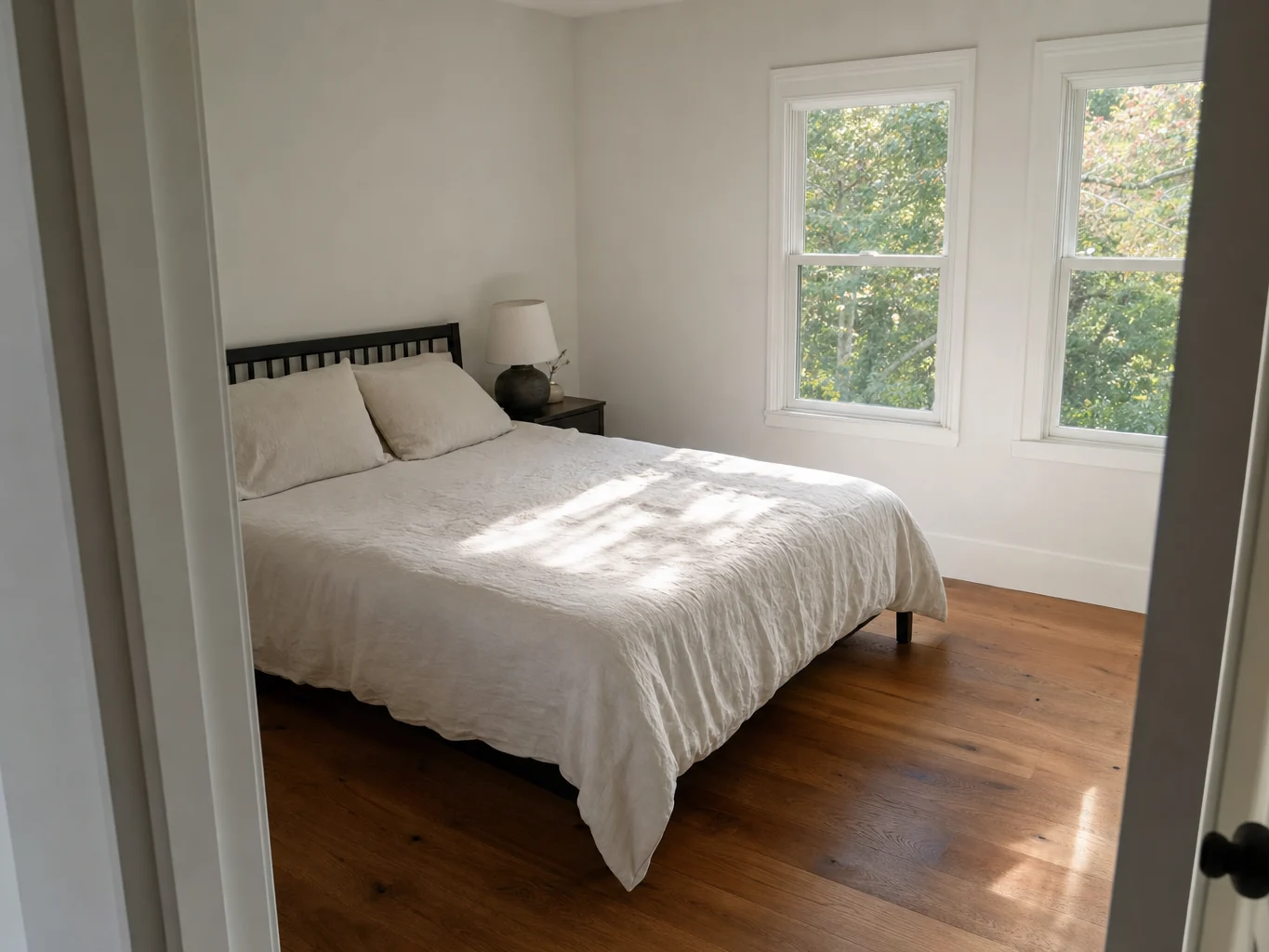 Finished bedroom with white trim and wide plank oak flooring