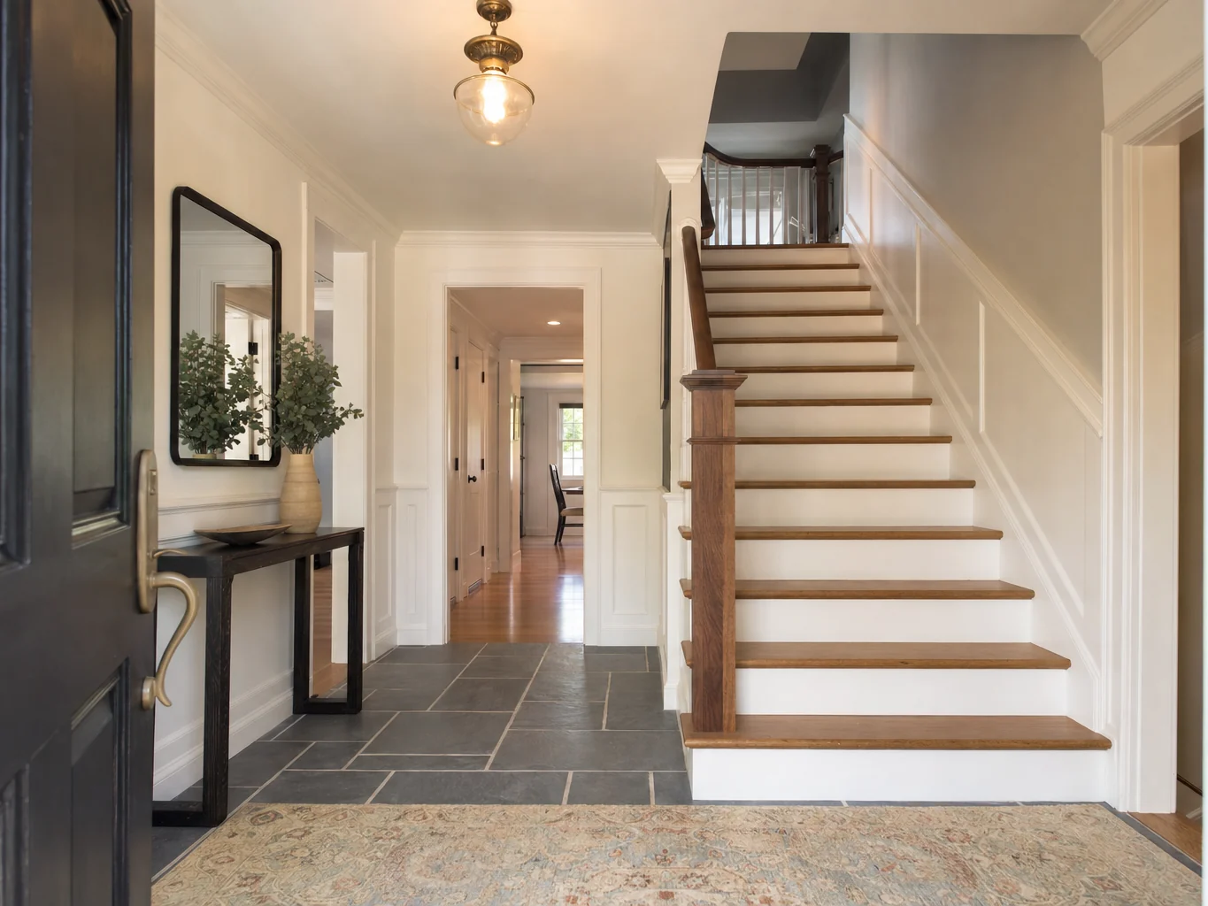 Entry foyer with staircase, wainscoting and tile floor