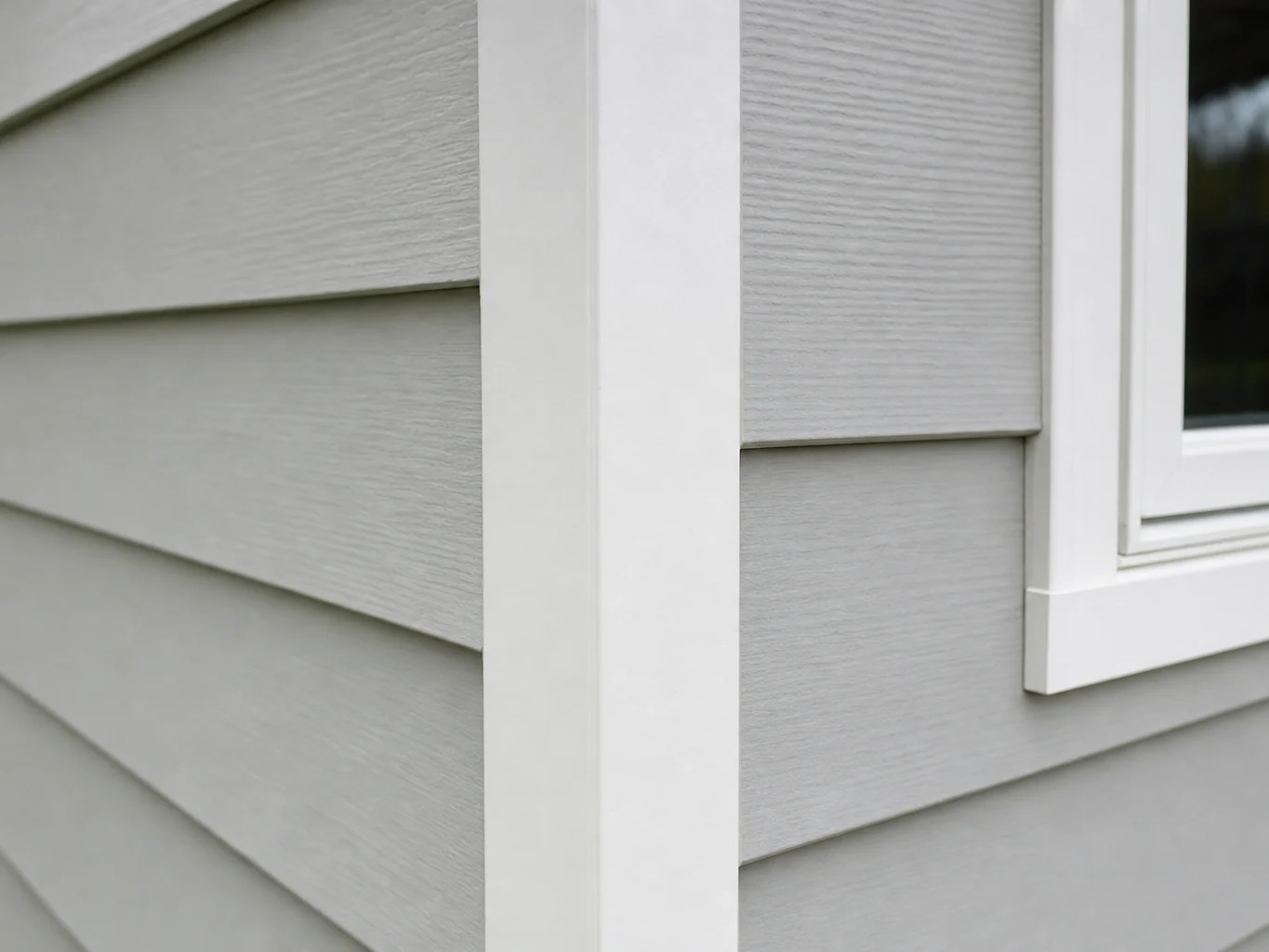 Corner post detail where lap siding meets white window casing