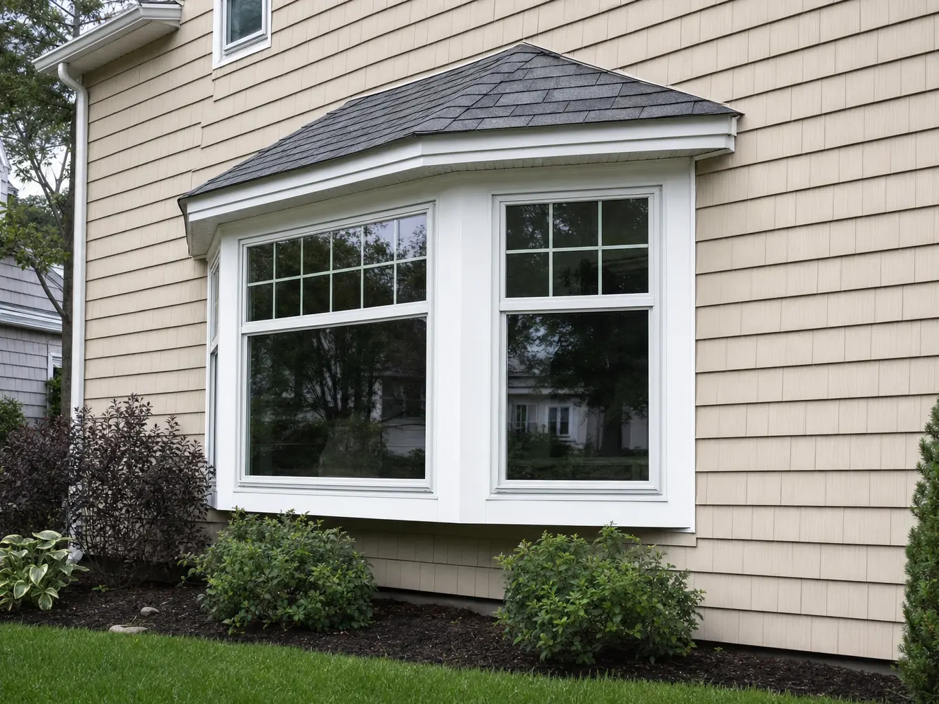 New bay window with shingled roof cap and white trim